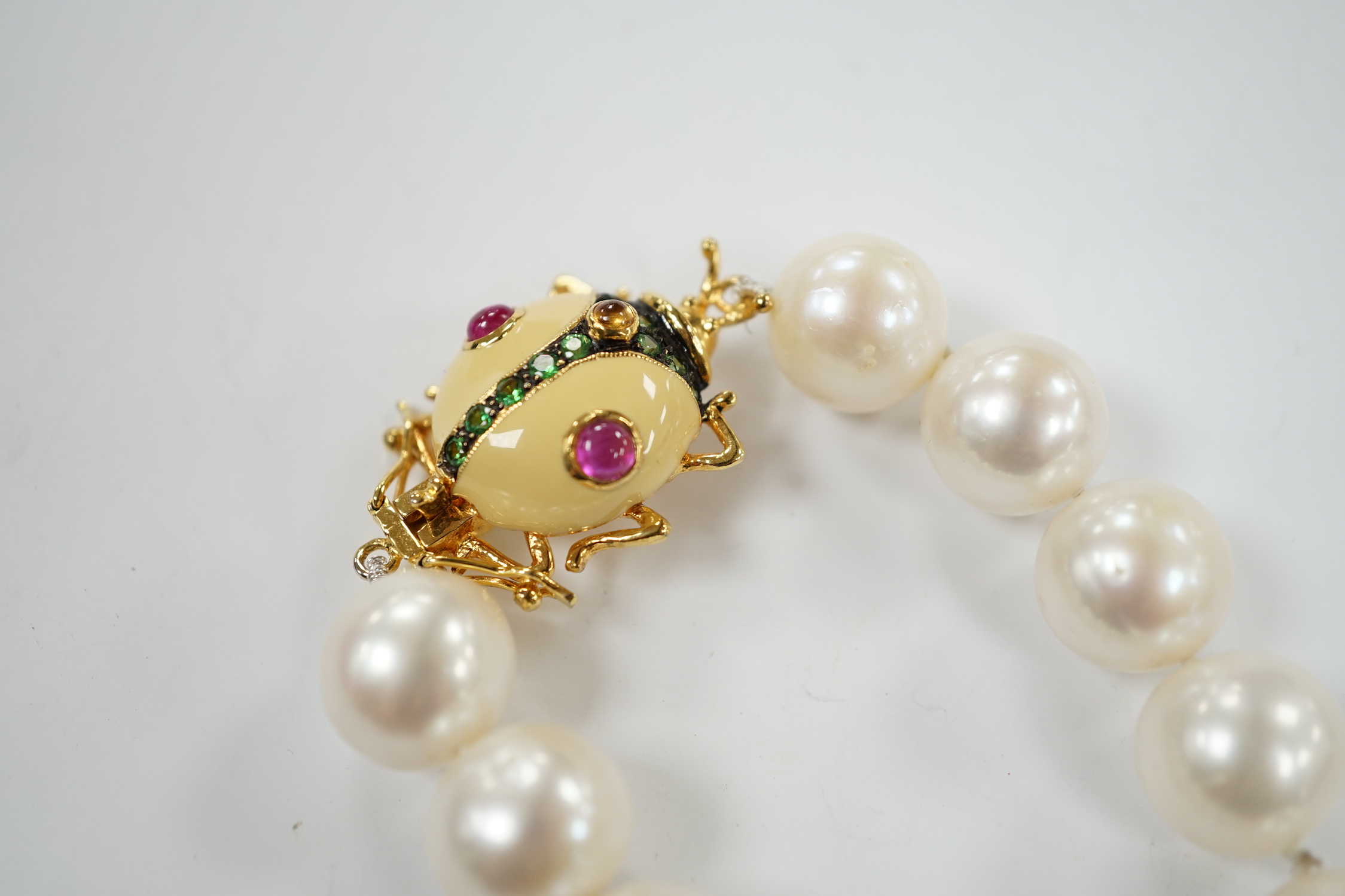 A Butler & Wilson single strand cultured pearl necklace, with enamelled and gem set bug clasp, 43cm.
